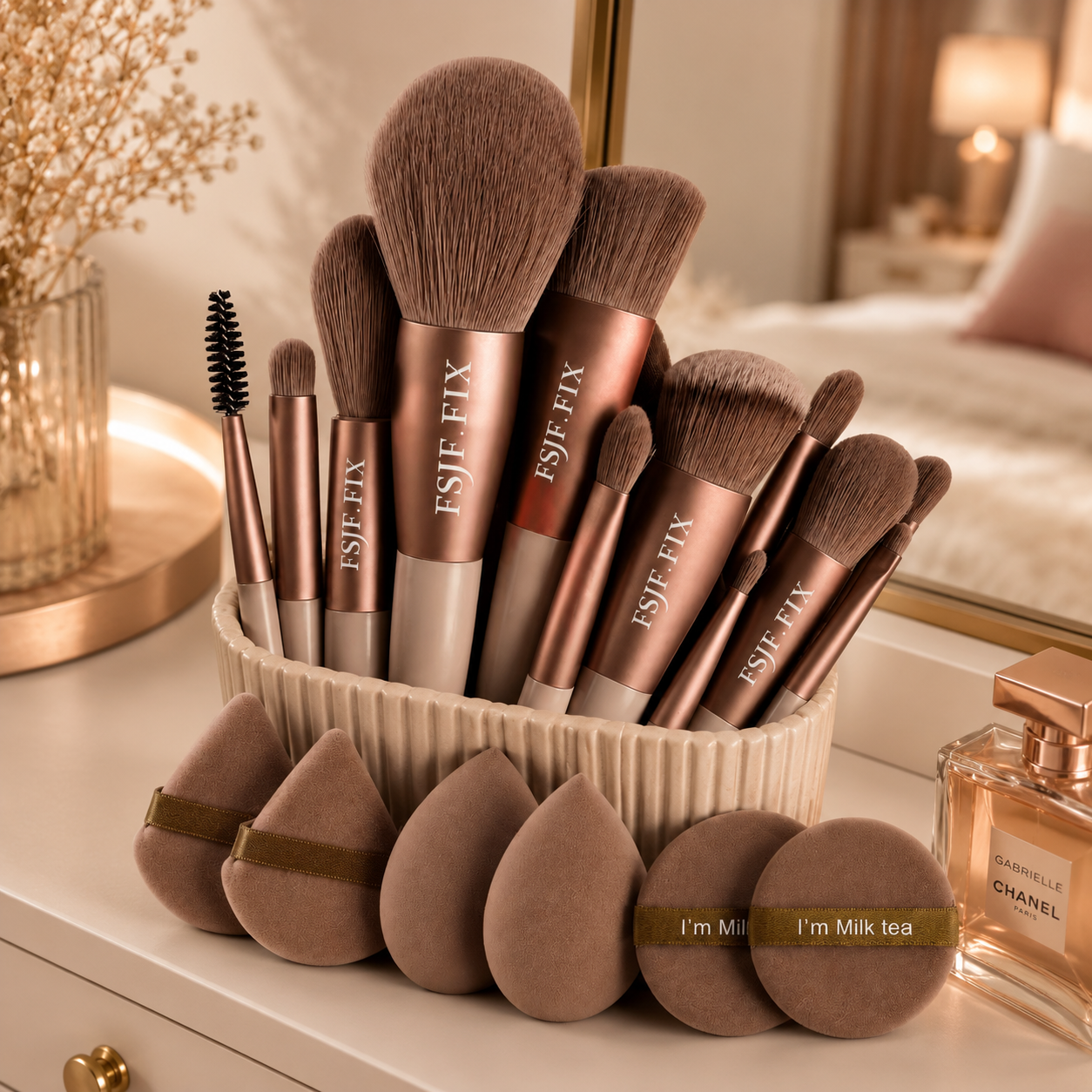 Professional makeup brush set with rose gold handles and beauty blending sponges displayed on a bedroom dresser vanity.